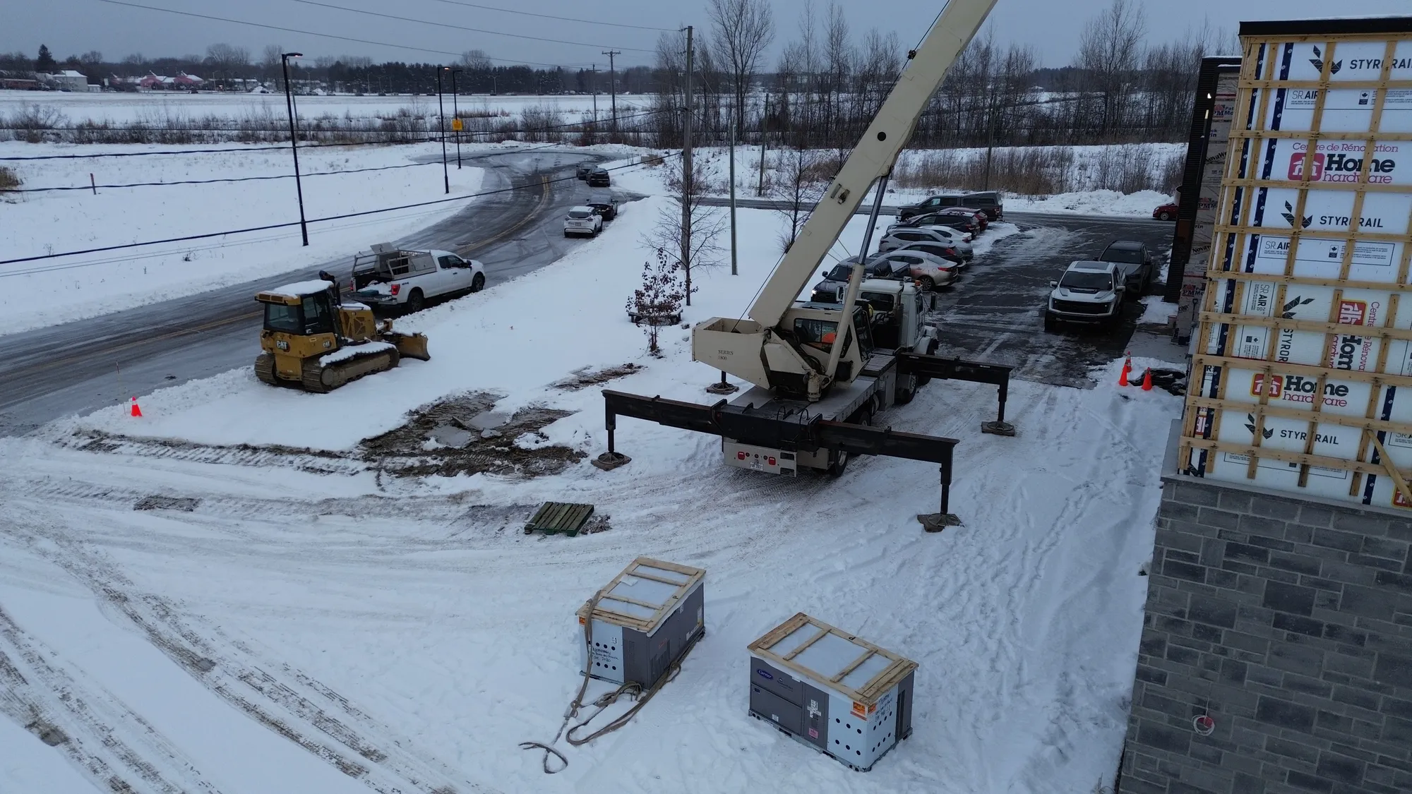 Chantier d'hiver avec grue et équipements mécaniques au sol